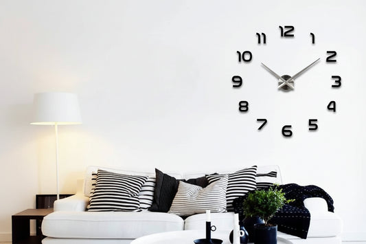 Large wall clock with black numbers and silver hands in a living room setting.